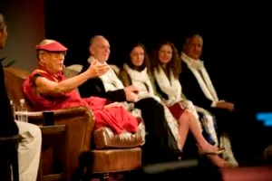The Dalai Lama appears onstage with Clare and Sara Bronfman.
