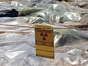 Warning signs which read “Caution, radioactive materials area” are posted around the hazardous pile on North Ave.