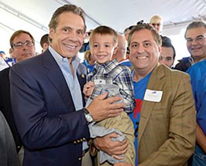 Andrew Cuomo holds Steve Pigeon’s nephew Landon at an event with Pigeon.
