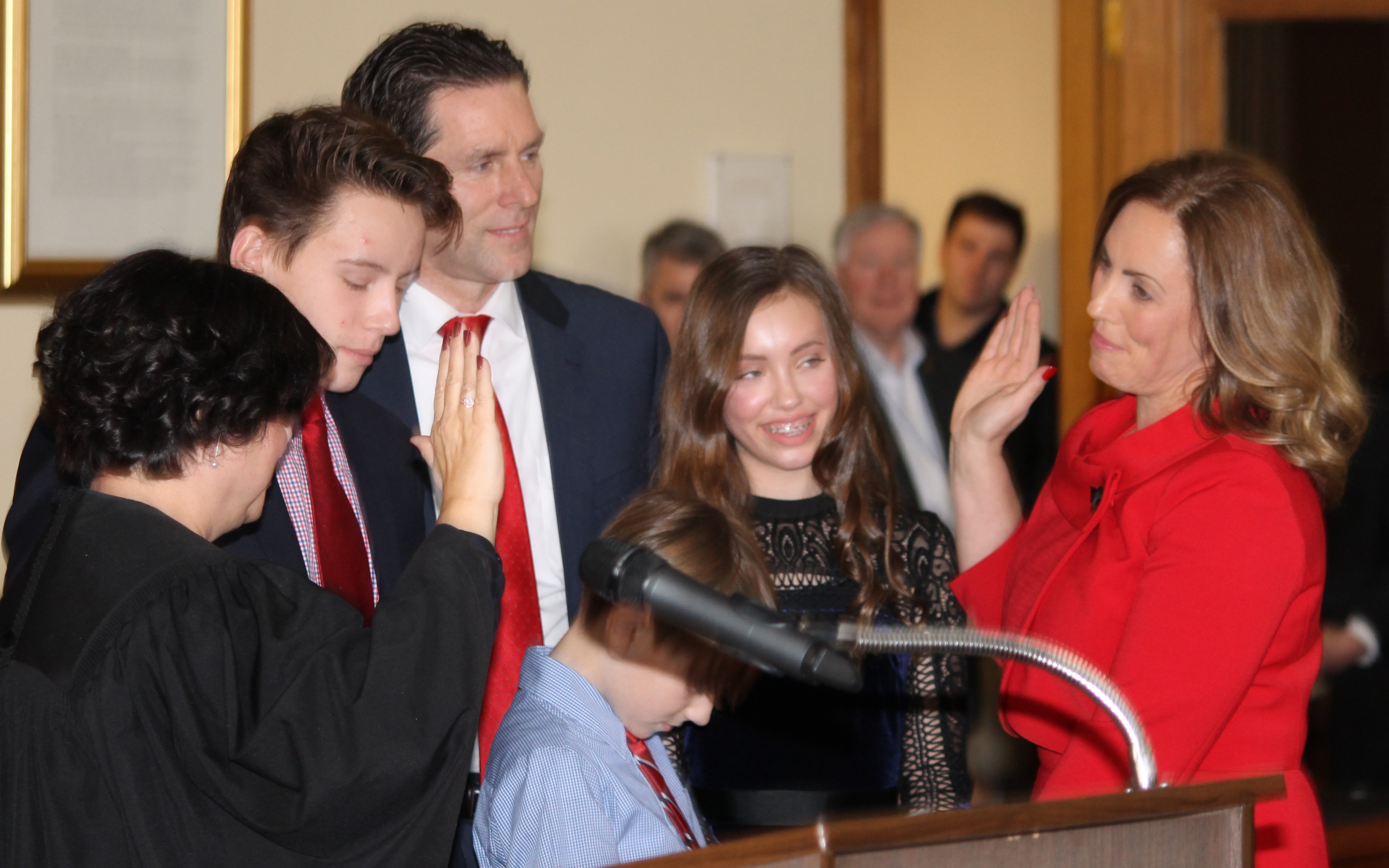 The new Niagara County District Attorney Caroline Wojtaszek is sworn in by Niagara County Judge Sara Sheldon as her husband Henry and son and daughter look on.