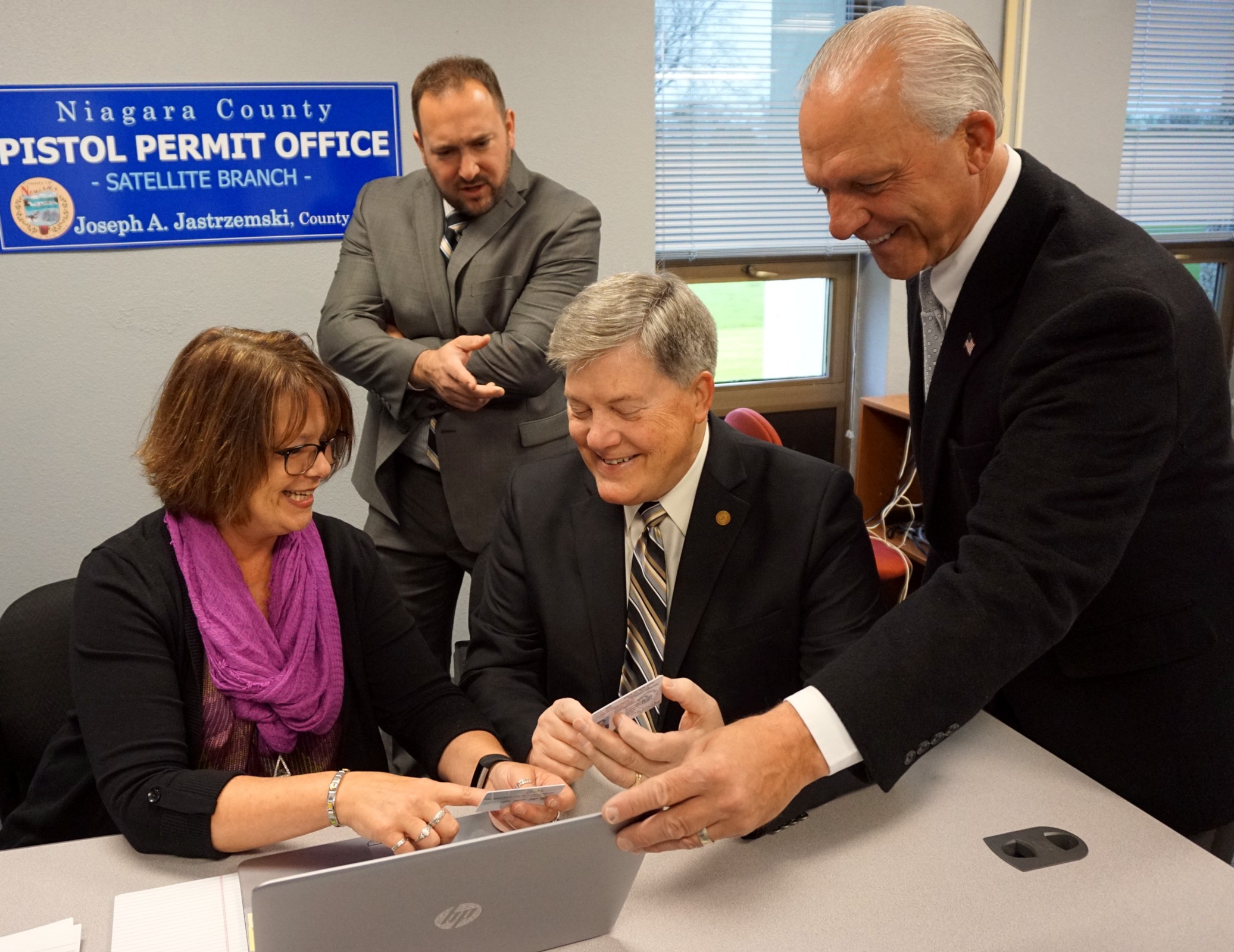 Niagara County Clerk Joe Jastrzemski, right, and County Legislator Rich Andres, R-North Tonawanda, standing, share a laugh with North Tonawanda Alderman-at-Large Jeff Glatz and Pistol Permit Clerk Patti Jo Sturak Friday during a test run of a remote "satellite" Pistol Permit Office that will be held in North Tonawanda on the second Wednesday of each month. A similar office is set for Niagara Falls, and will be held the fourth Wednesday of each month.